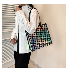 Detail of holographic tote bag with black heart patterns worn by a model in a side view