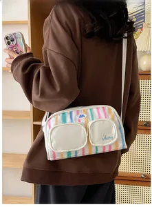 Detail of trendy nylon shoulder bag with colorful rainbow stripes and functional multi-pockets