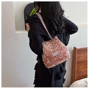 Close-up of pink sequin crossbody bag with metal chain strap worn by a model
