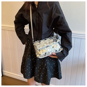 Detailed close-up of a trendy silver sequin crossbody bag with a shiny metal lock buckle
