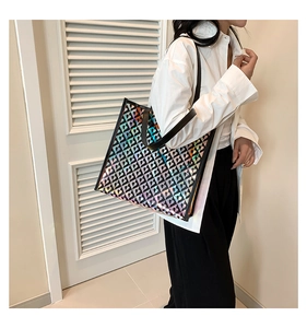 Detailed shot of large holographic tote bag with black heart patterns and contrast handles