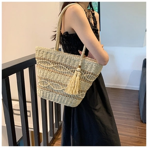 Détail du sac à bandoulière en paille tressé à la main avec franges et textures boho