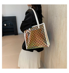 Detailed side view of holographic tote bag with black hearts and white leather handles