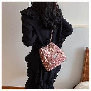 Detail of pink sequin bucket bag featuring a silver chain strap and drawstring closure