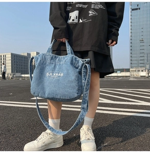 Detailed macro view of retro blue denim tote bag texture with white embroidered logo design