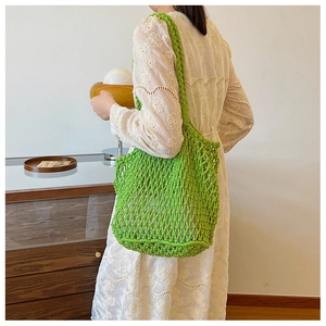 Detail of neon green woven mesh tote bag with thick strap on a minimalist lifestyle setting