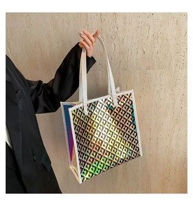 Detailed holographic tote bag with black heart prints and white leather handles