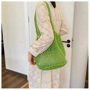 Detailed macro view of bright green hand-woven mesh shoulder bag with thick cord texture