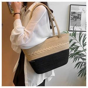 Close-up of beige and black woven tote bag with intricate texture and braided handles