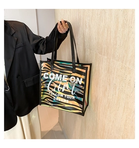 Close-up of zebra print PVC tote bag with stylish leather handles and motivational slogan