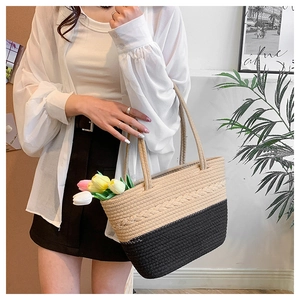 Detail of hand-woven beige and black contrast texture on stylish tote bag with shoulder strap