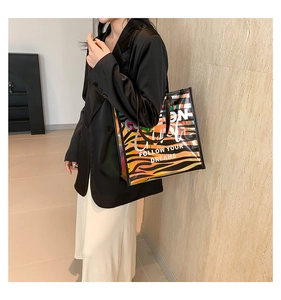 Detail view of holographic tiger stripe tote bag with Follow Your Dreams text