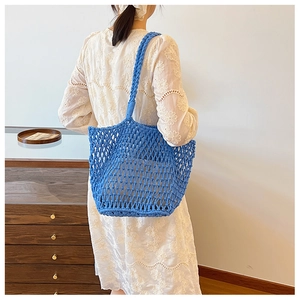 Blue woven hollow shoulder bag with large mesh cotton rope design on a model