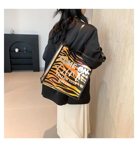 Detail of laser tiger print tote bag with COME ON Girl text and glossy metallic finish