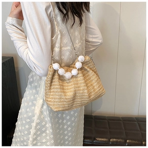 Détail de la texture en paille tressée et de la poignée décorative en perles blanches