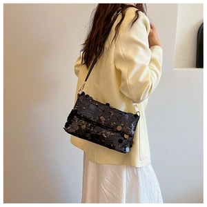 Detail of black sequin shoulder bag showing large round sequins and silver metal hooks