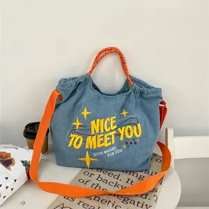 Borsa tote in denim con ricamo giallo, manici arancioni e tracolla larga regolabile