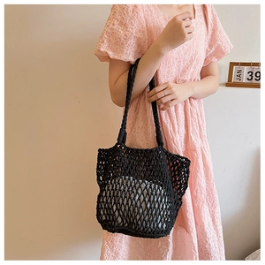 Detail of black woven mesh tote bag with white drawstring inner pouch and dual straps