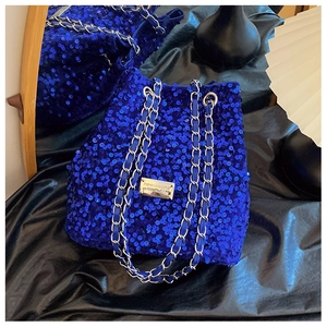 Chic royal blue sequin bucket bag with silver chain strap on black silk background