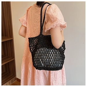 Detailed texture of black woven mesh shoulder bag with a blue drawstring inner lining