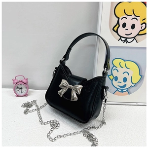 Detail of glossy PU leather handbag with silver bow buckle and chain strap