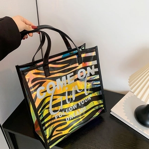Holographic zebra print tote bag with 'FOLLOW YOUR DREAMS' slogan and black handles