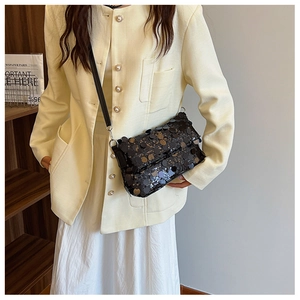 Close-up of stylish black sequin crossbody bag on model with modern rectangular design