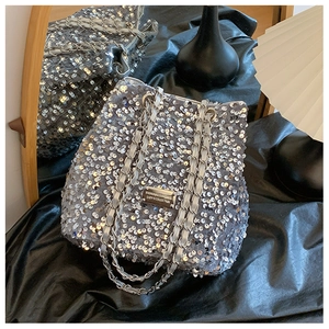 Sparkling silver sequin bucket bag with chain strap and metal plaque on black silk