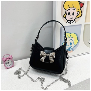 Detail of black PU leather handbag featuring a silver metal bow clasp and chain strap