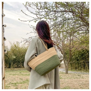 Detail view of woven fabric tote bag in beige and green featuring braided textures