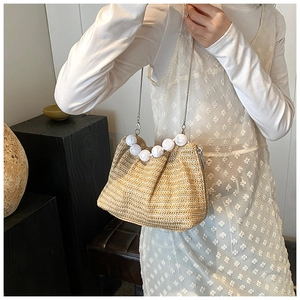 Vue détaillée du sac à bandoulière en paille tissée avec poignée en perles et chaîne métal