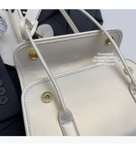 Detail shot of the hidden magnetic clasp and inner lining on a white PU leather handbag