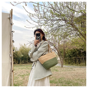 Detail of a color-block woven shoulder bag in olive green and natural beige wood tones