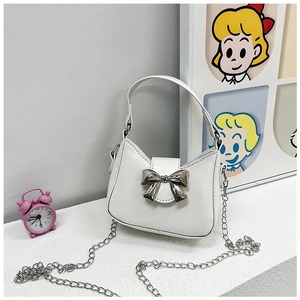 Detail of white PU leather mini bag featuring silver metallic bow and chain strap