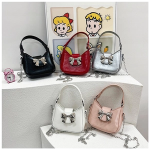 Mini chain crossbody bags in multiple colors with metallic bow clasps and PU leather finish