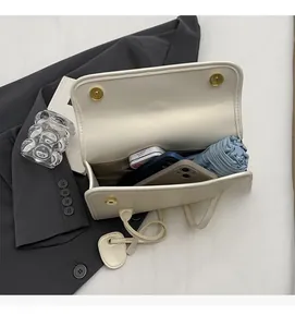 Interior view showing the large capacity of the cream PU shoulder bag with daily essentials