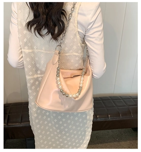 Borsa hobo rosa in similpelle con catena grossa e perle su abbigliamento in pizzo bianco