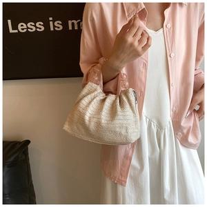 Détail du sac à bandoulière en paille tissé avec poignée en perles transparentes