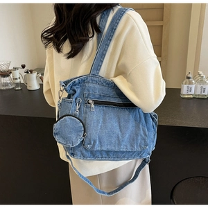 Detail of blue denim tote bag with external zipper pocket and small round coin purse