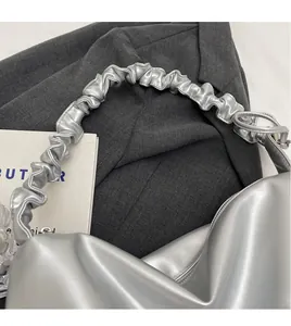 Detailed view of silver metallic PU shoulder bag with trendy pleated cloud strap design