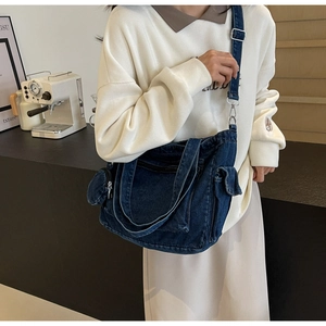 Detail of dark blue denim tote bag with adjustable strap and mini zipper pouch
