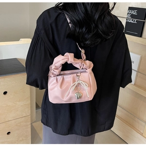 Pink pleated cloud bag detail with pearl bow and silver heart pendant decoration