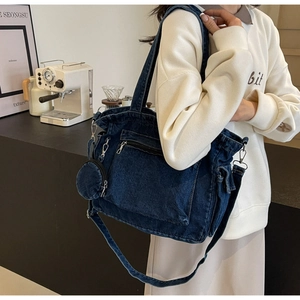 Detail of dark blue denim tote bag with detachable shoulder strap and round coin purse