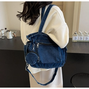 Detail of blue denim tote bag with silver zippers and a detachable small round coin purse