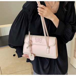 Detail of soft pink PU leather shoulder bag with butterfly embroidery and slim handles
