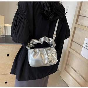 Detail of silver metallic PU pleated bag with pearl bow charm and heart pendant
