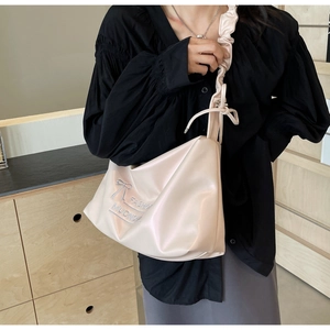 Detail view of cream PU leather shoulder bag featuring bow decor and fashion embroidery