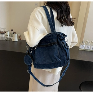 Detail of dark blue denim tote bag with side pockets and matching round pouch accessory