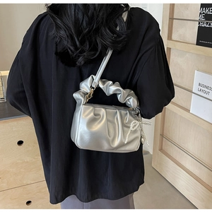 Detail view of silver PU cloud bag featuring stylish pleats and a decorative pearl knot charm