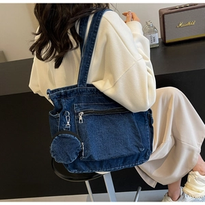 Detail view of denim tote bag with side pockets and mini coin purse in a lifestyle setting